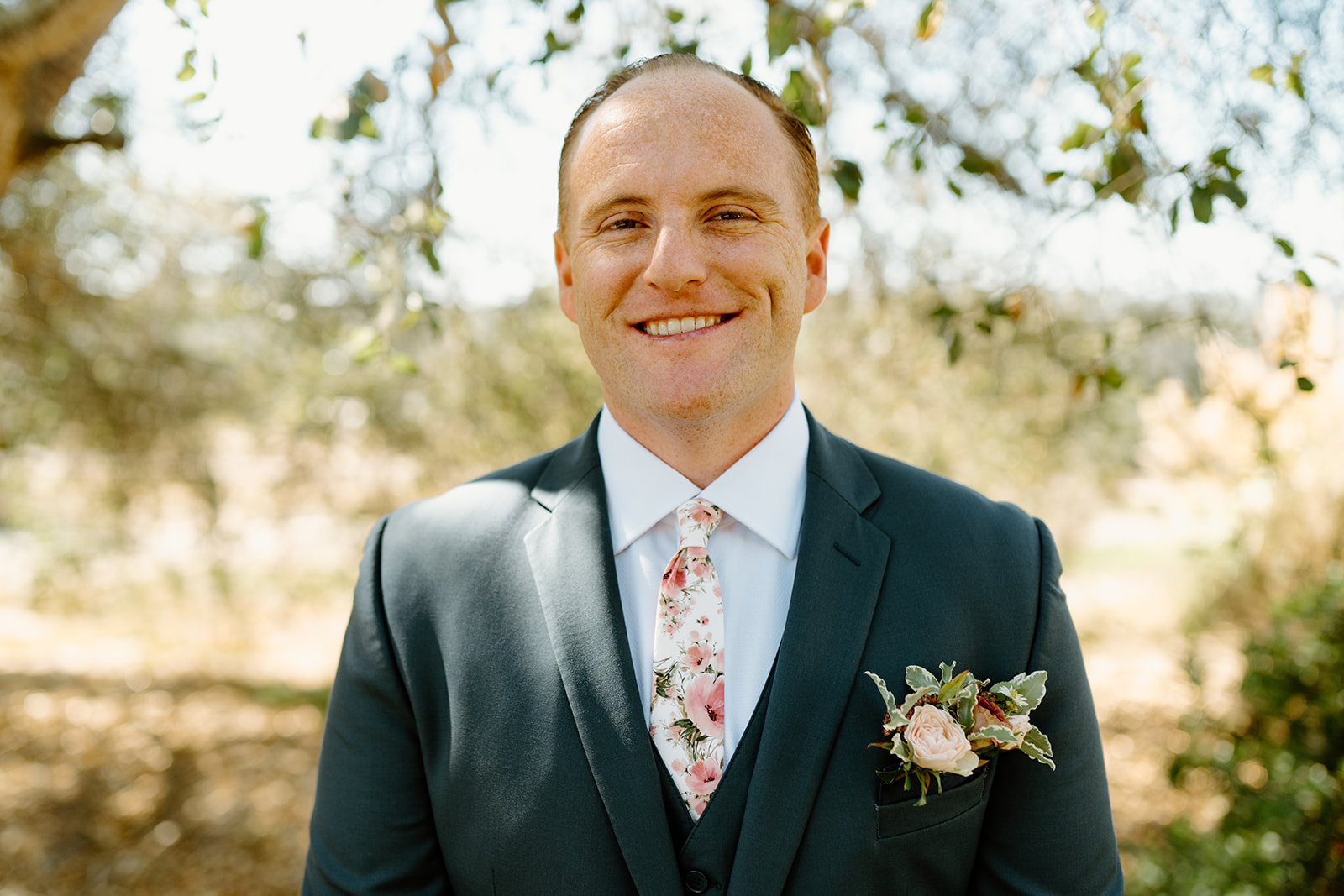 Groom smiles at camera at The White Barn in San Luis Obispo CA, photography by Cobblestone