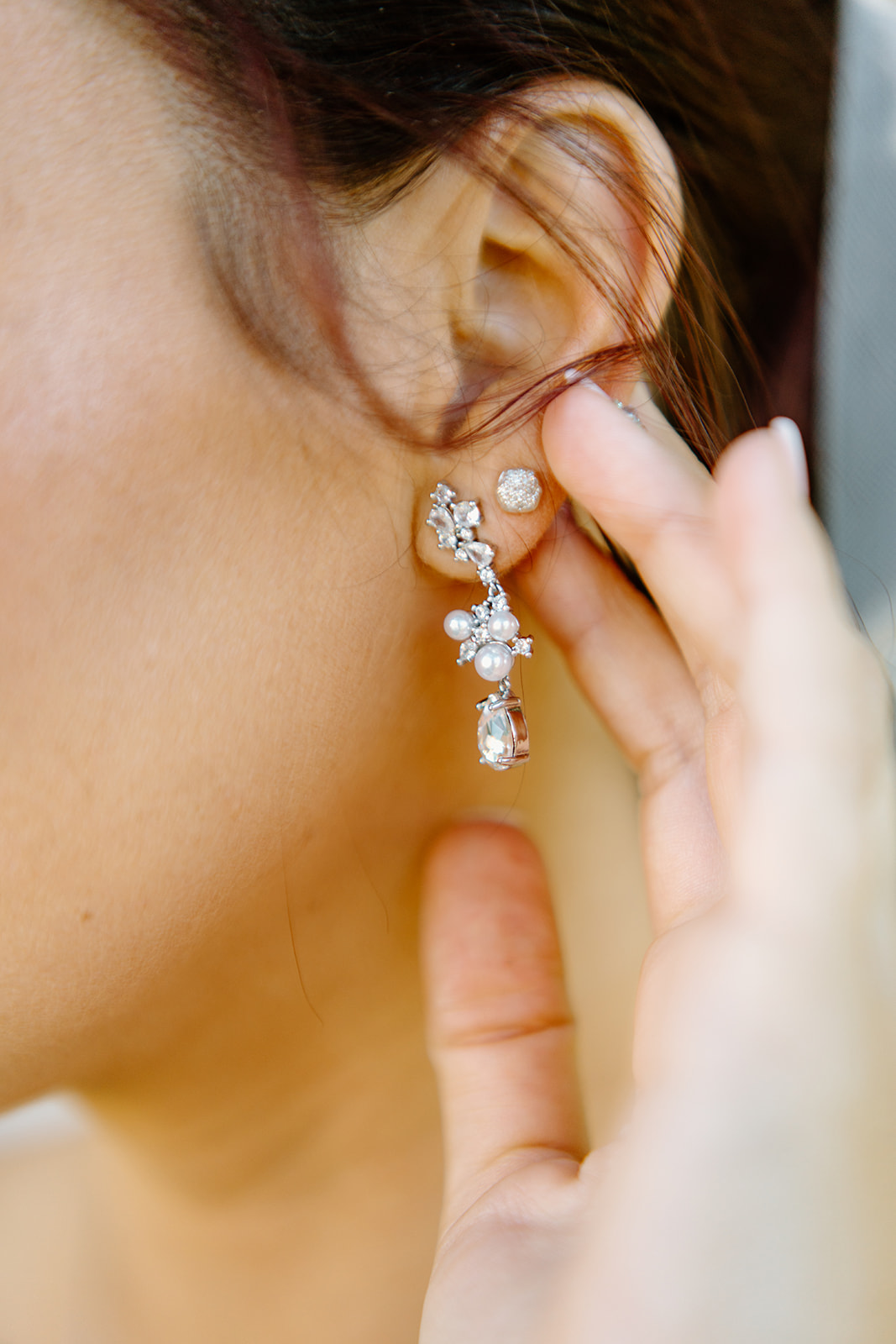 Bride looks at earring at The White Barn in San Luis Obispo CA, photography by Cobblestone